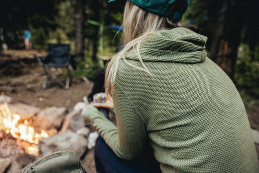 A woman camping in a waffle knit merino hoody.