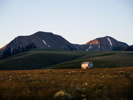 A sheep wagon amidst Montana mountains.