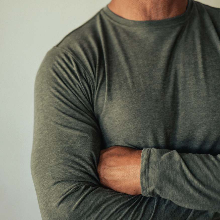 A man wearing a green American made Duckworth merino wool light weight long sleeve crew.