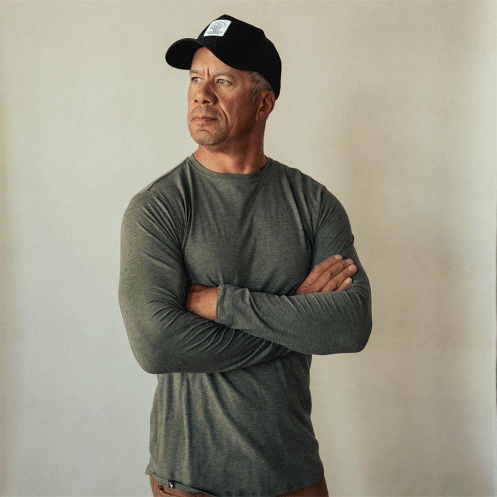 A man wearing a green American made Duckworth merino wool light weight long sleeve crew.