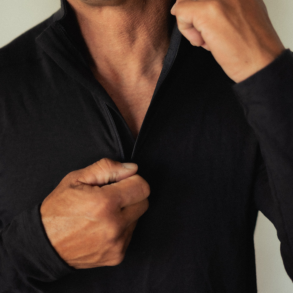 A man wearing a black American made merino wool quarter zip.