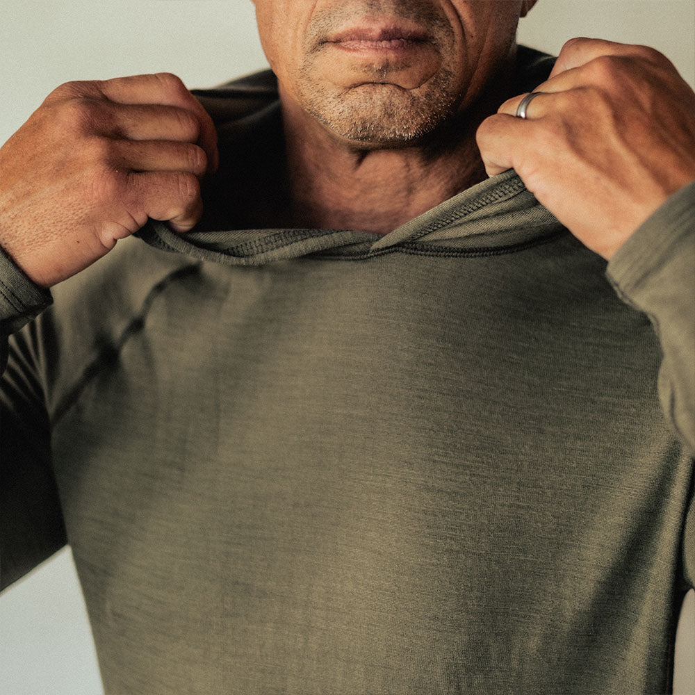 A man wearing a green American made Duckworth merino wool hoody. 