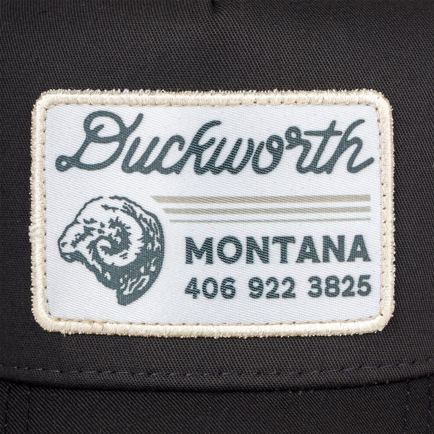 A Duckworth patch on a black hat including a phone number and Ram head.