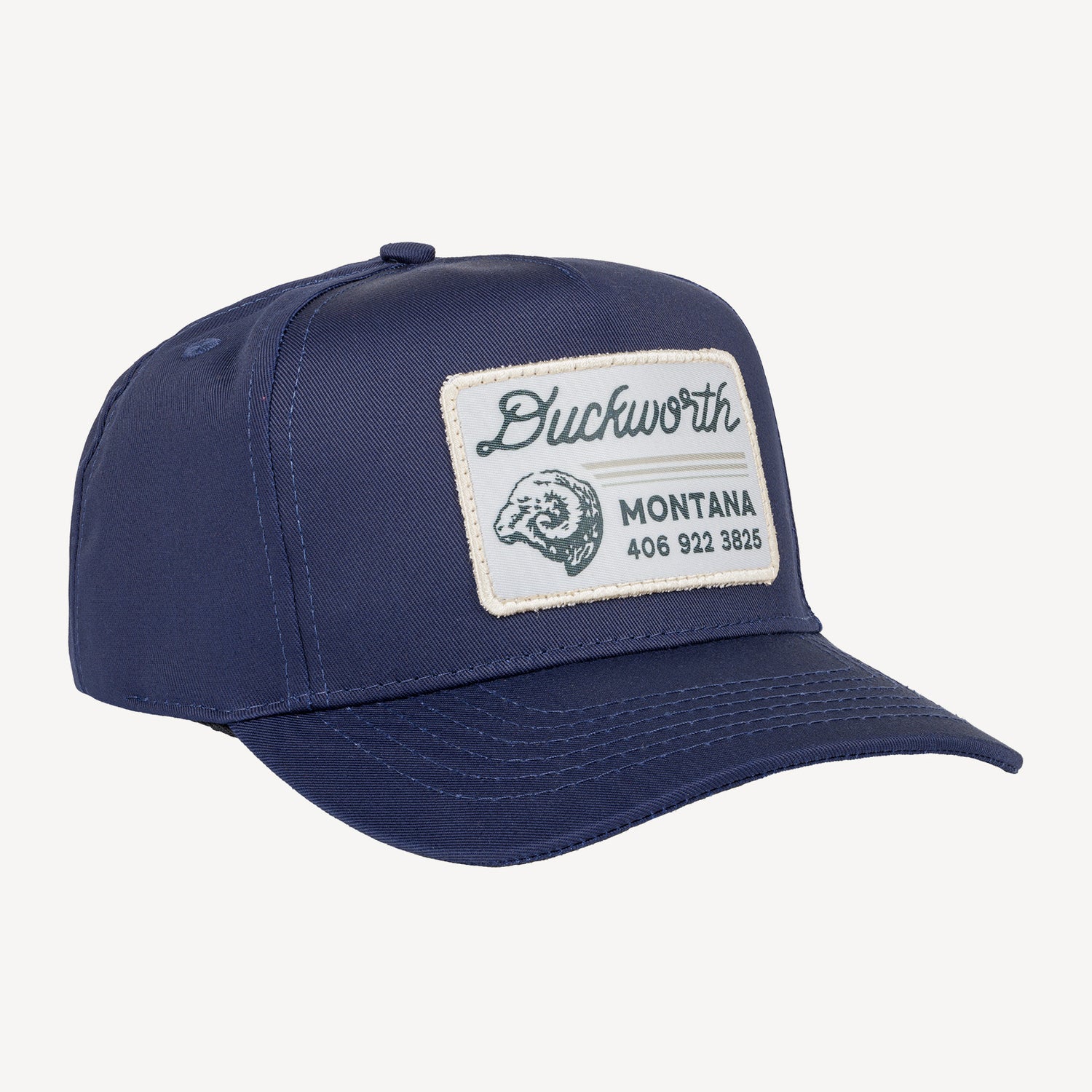 A blue hat with a Montana patch with a ram's head on it.