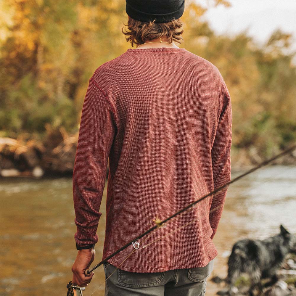 A fly fisherman wearing a red American made merino wool baselayer. 