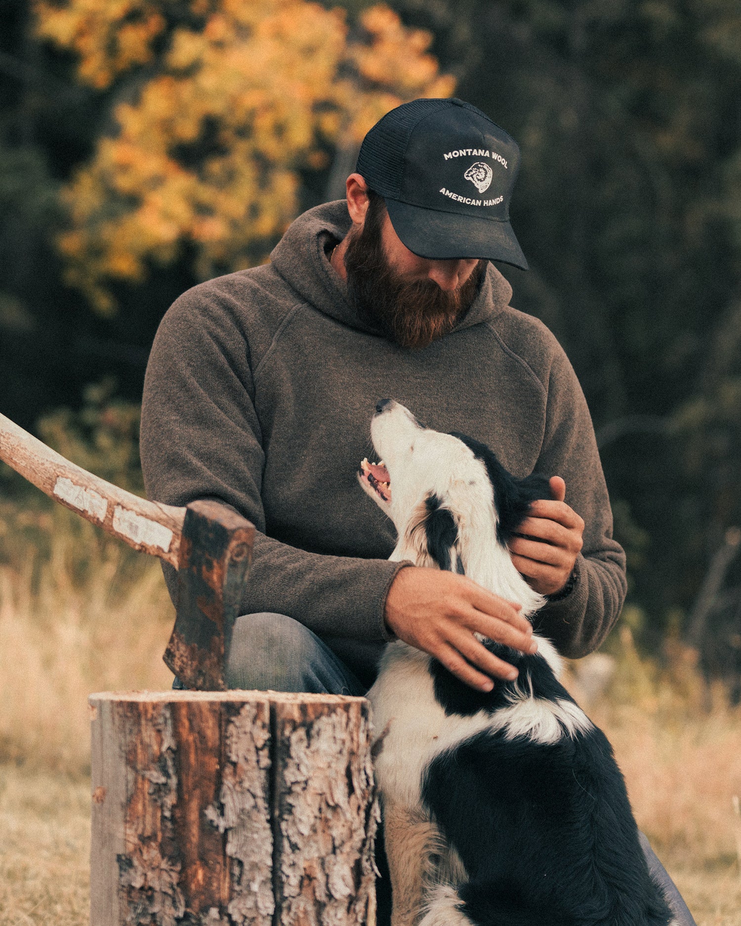 A man with his dog wearing a merino wool hoody in the fall. 