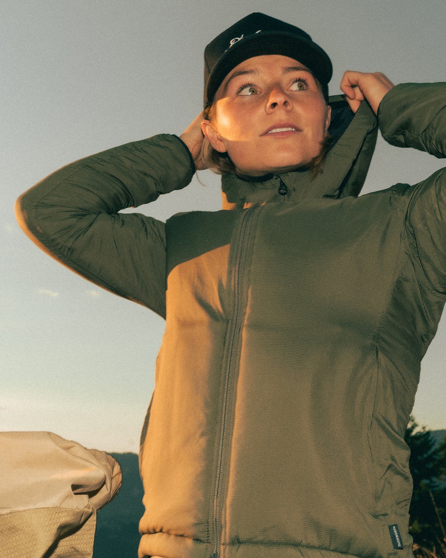 A woman hiking while wearing a Montana merino wool insulated jacket.