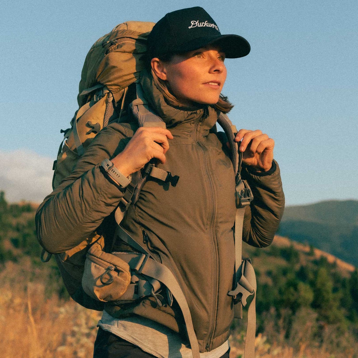A woman wearing a gray American made Duckworth wool insulated soft shell jacket.