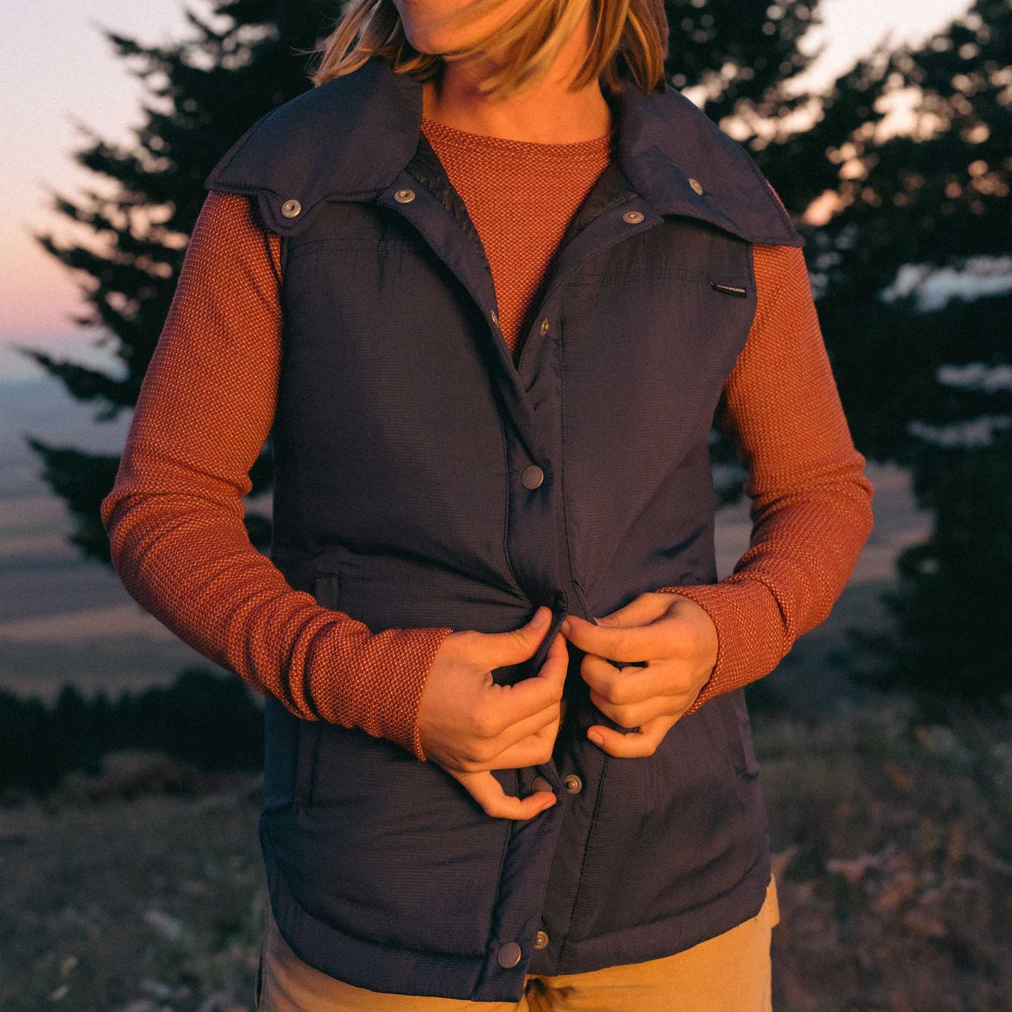 A woman wearing a blue American made Duckworth wool insulated soft shell vest.