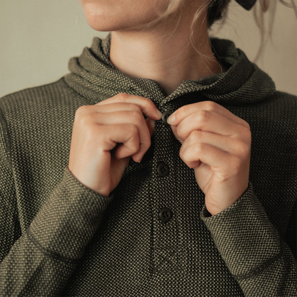 A woman wearing a green American made Duckworth merino wool waffle knit hoody.